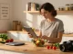 Bright kitchen with person using the best food tracker while preparing a healthy meal
